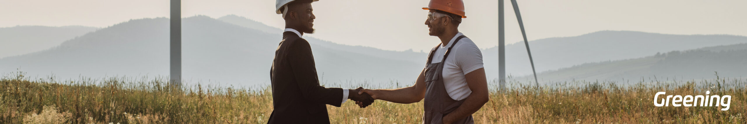 Dos profesionales estrechando la mano frente a aerogeneradores, representando un acuerdo PPA de energía renovable.