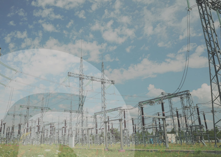 Subestación eléctrica de alta tensión con infraestructura de transmisión y distribución energética bajo un cielo parcialmente nublado.